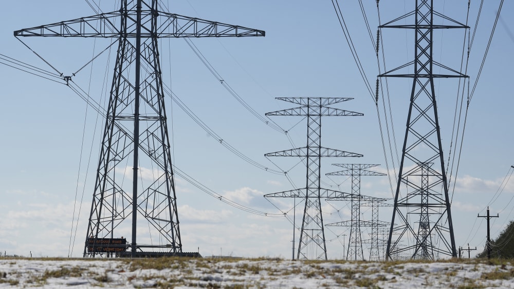 Transmission lines with snow on the ground are shown along the North Sam Houston Parkway near SH249.