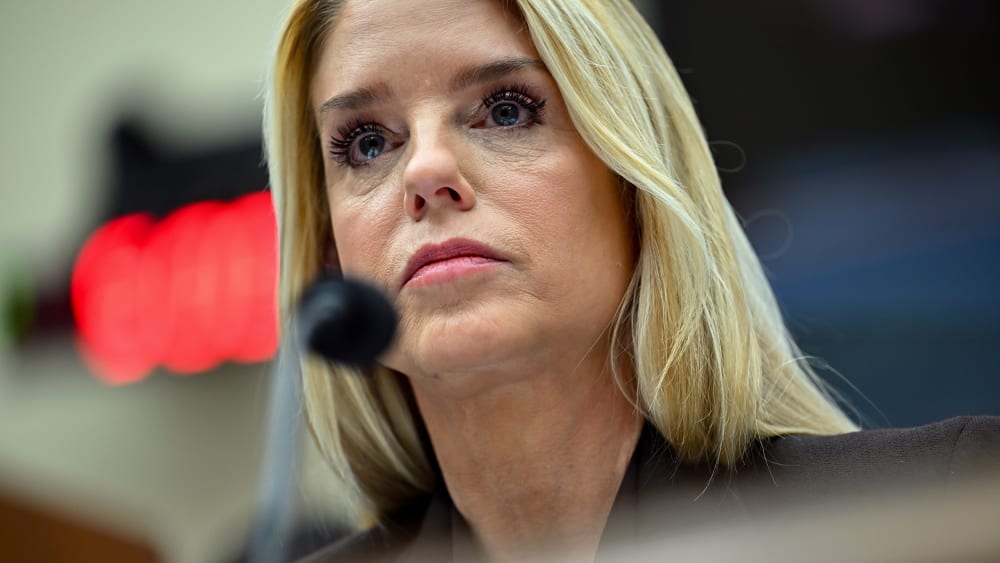A close up of Pam Bondi behind a microphone.