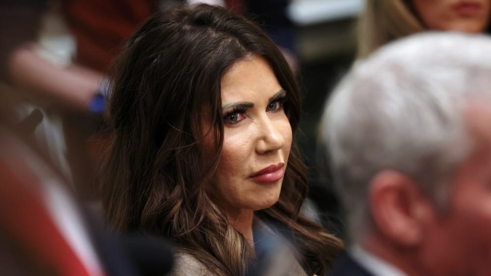 Kristi Noem sits among other cabinet members.