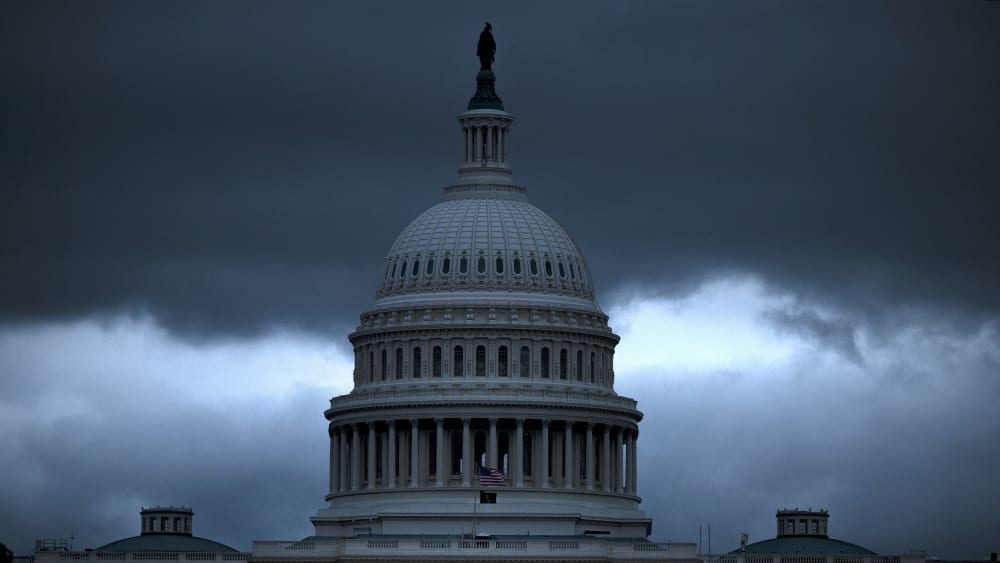The Capitol building with dark, ominous clouds in the background.