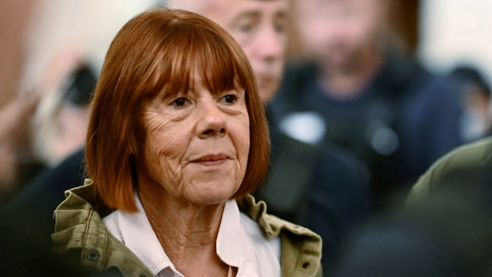 Gisele Pelicot stands among a group of people.