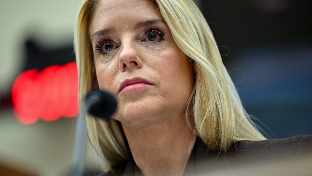 A close up of Pam Bondi behind a microphone.