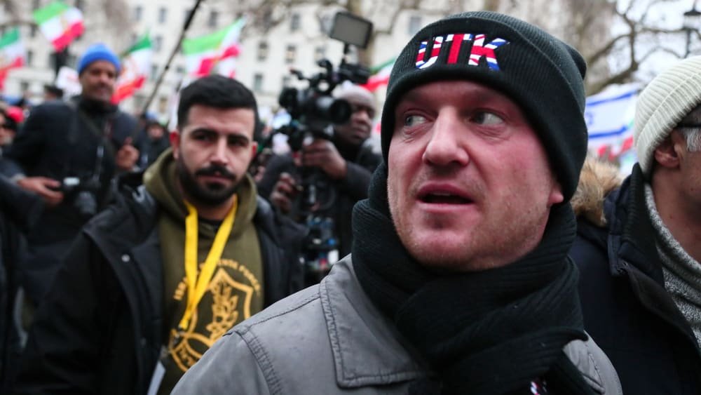 Tommy Robinson looks on as he participates in a rally outdoors in London.