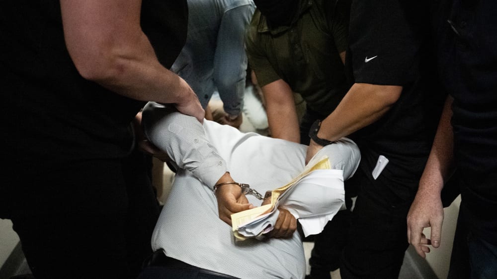 Ice agents detain a person as he exits an immigration courtroom hearing at the Jacob K. Javitz Federal Building.