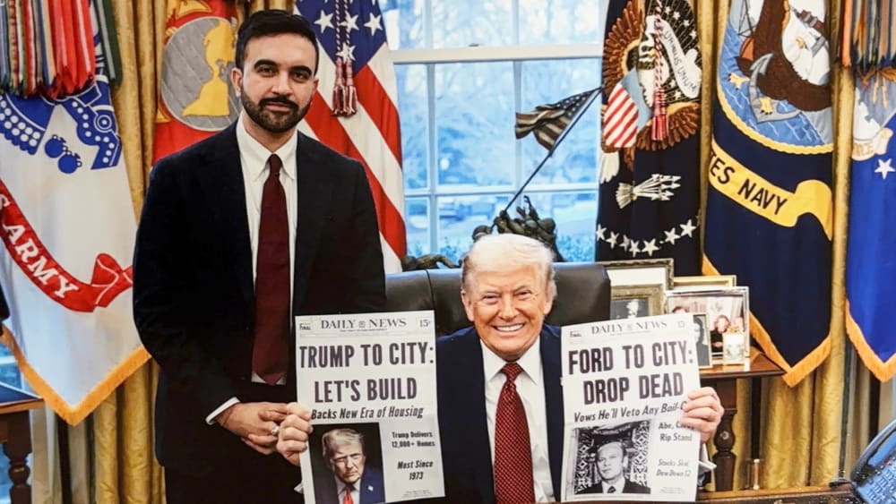 Donald Trump holds two cover pages of Daily News one of which reads "Trump To City: Let's Build" about building affordable housing. This cover page is made up and given to Trump by Mamdani as a gift.