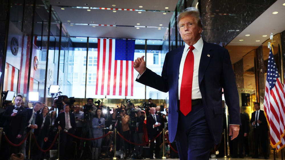 Donald Trumps poits at the journalists behind him.