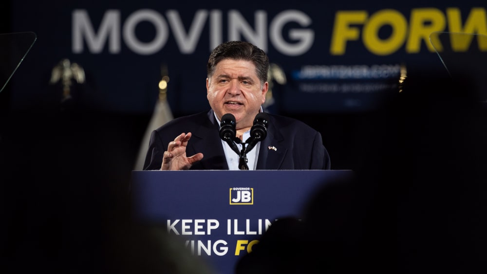 JB Pritzker speaks at a podium that says "Keep Illinois Moving Forward."