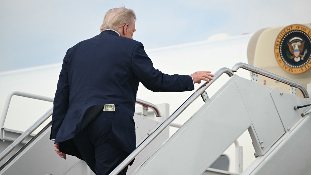 A fifty-dollar bill is seen in President Donald Trump's back pocket as he boards Air Force One.
