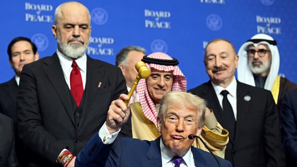 Donald Trump, center, lifts a gavel while surrounded by world leaders.