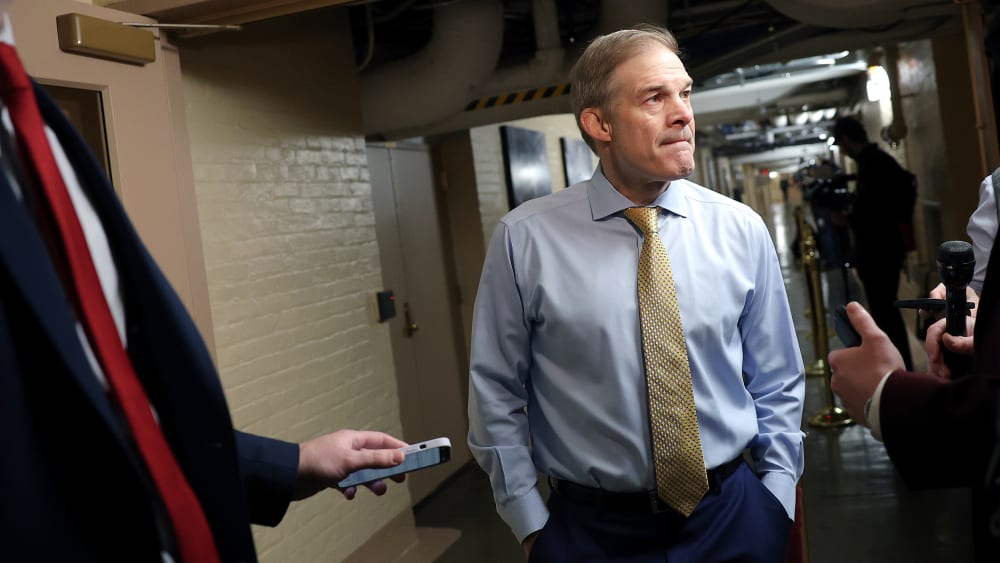 Jim Jordan has his hands in his pockets while speaking to the reporters.