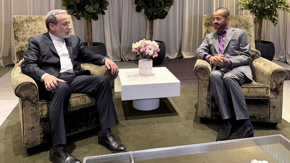 Abbas Araghchi, left, speaks to Badr Albusaidi as they sit side by side at arm chairs.