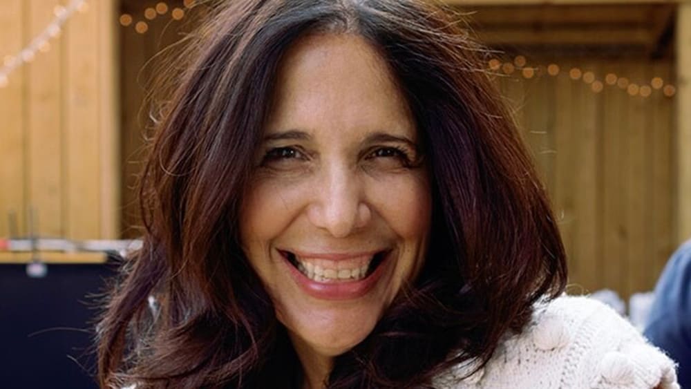 Sue Zarco Kramer smiles at an outside venue.