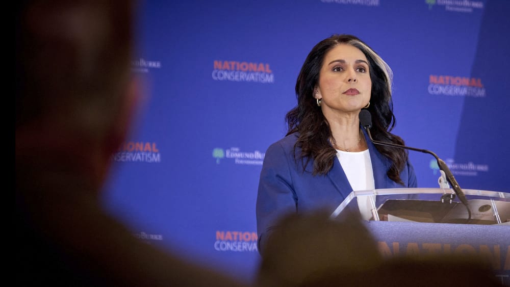 Tulsi Gabbard seen on stage through the audience's heads.