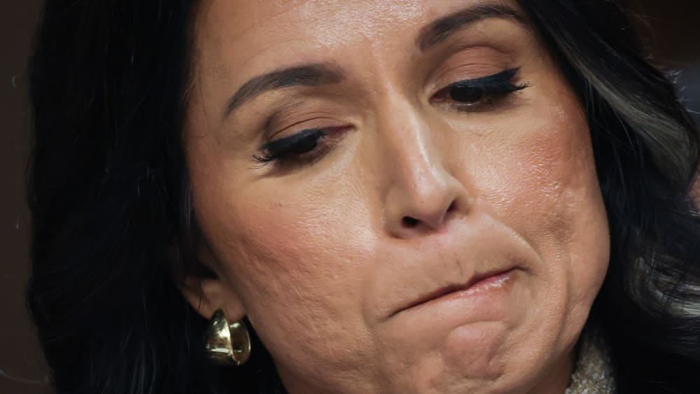 A close up of Tulsi Gabbard as she bites her lip.