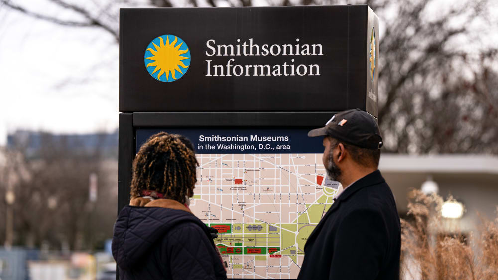 Two people look at a permanent map titled "Smithsonian Museums in the Washington, D.C., area."