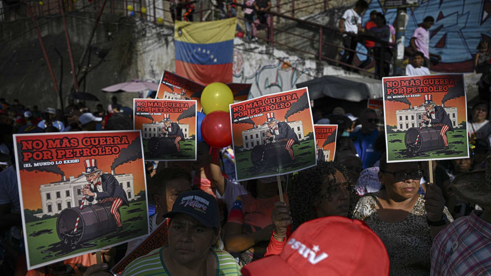 Supporters of Venezuelan President Nicolás Maduro show signs that read, in Spanish, “No more war for oil, the world demands it.”