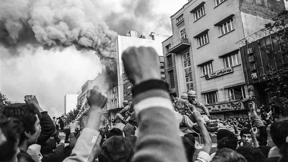 Troops loyal to Shah Mohammad Reza Pahlavi arrive to control a crowd of demonstrators outside a burning government building at the height of Islamic revolutionary fervor on Nov. 4 1978 in Tehran.