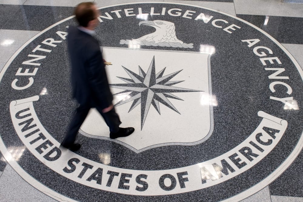 A man crosses the Central Intelligence Agency (CIA) seal in the lobby of CIA Headquarters in Langley, VA.