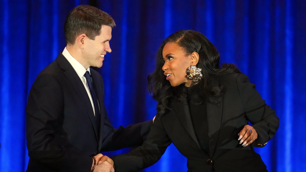 State Representative James Talarico and Representative Jasmine Crockett shake hands during a debate.