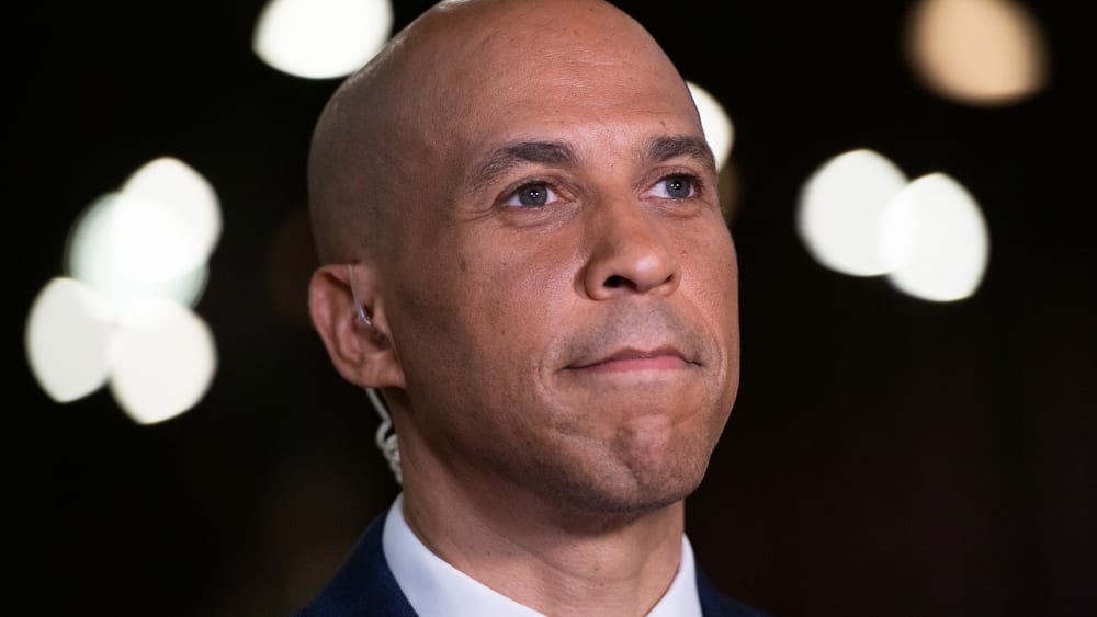 A close up of Cory Booker smiling subtly.