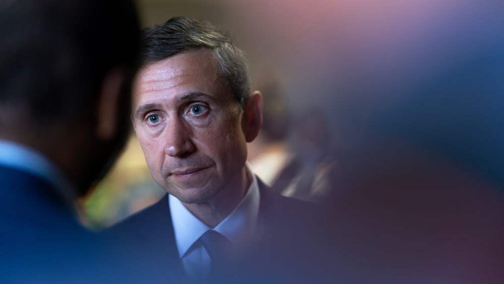 Ken Martin, chairman of the Democratic National Committee, partially obscured by reporters.