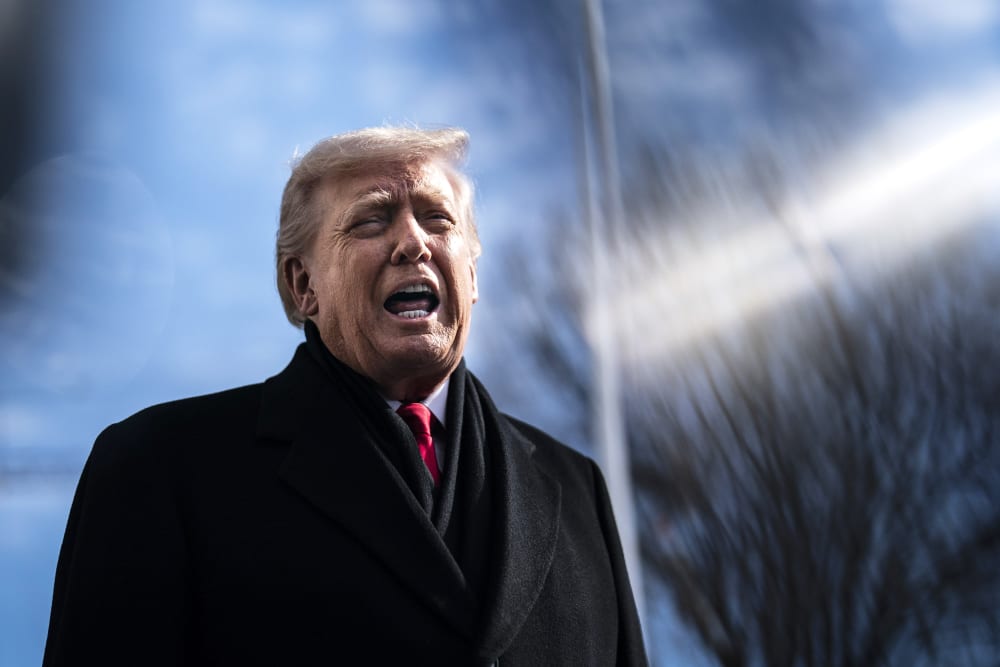 President Trump is talking to reporters outside in a frame photographed from below.