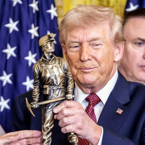 Jim Grech, president and chief executive officer of Peabody Energy Corp., presents President Donald Trump with a trophy during a "Champion of Coal" event in the East Room of the White House.