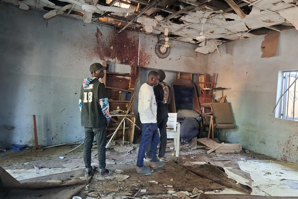 People inspect the scene of a deadly bomb explosion inside a mosque on Dec. 25 in Maiduguri, Nigeria.