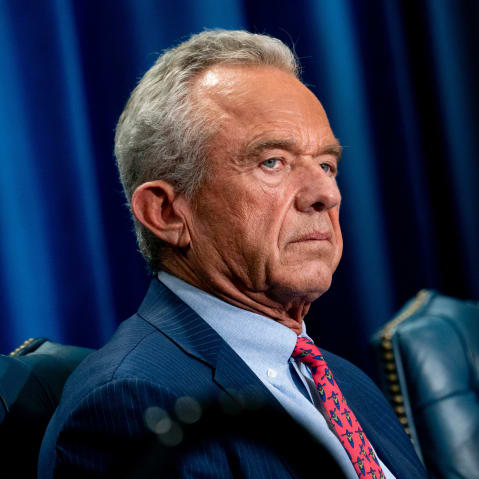 Robert F. Kennedy Jr. sits in a blue leather chair in front of a blue curtain.