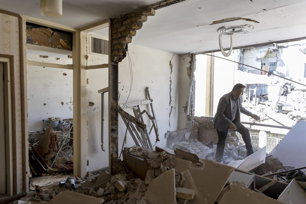 A man walks through a damaged residential building, struck days earlier, during the U.S.-Israeli military campaign in Tehran, Iran.