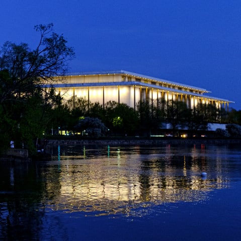 The Kennedy Center reflected in the Potomac River at dusk.