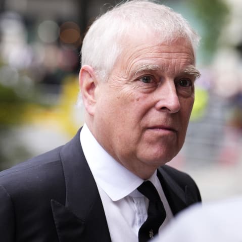 A medium shot shows former British royal Andrew talking to someone.