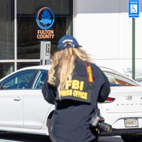 An FBI press office person approaches the Fulton County Election Hub and Operation Center on Jan. 28, 2026, in Union City, Ga.