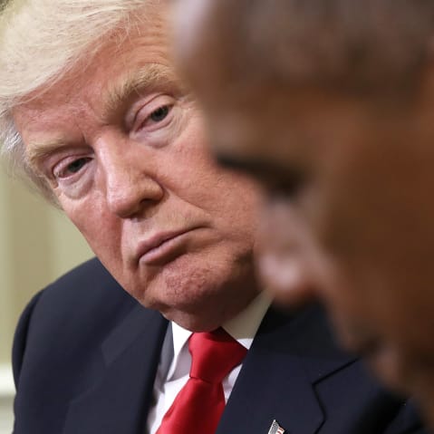 Donald Trump, in focus on the left, looks at Barack Obama, who is out of focus in the foreground.