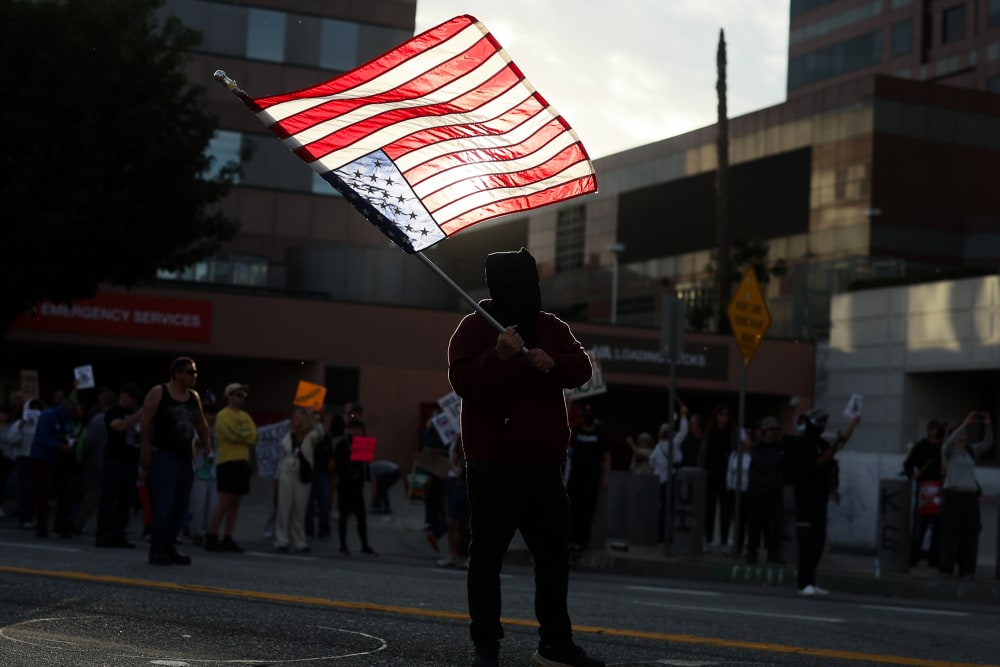 A demonstrator waves an upside-down United States flag in protest of a second shooting death by immigration officers in Minnesota.