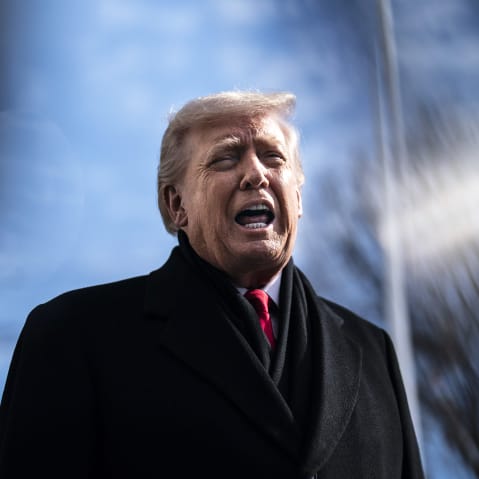 President Trump is talking to reporters outside in a frame photographed from below.