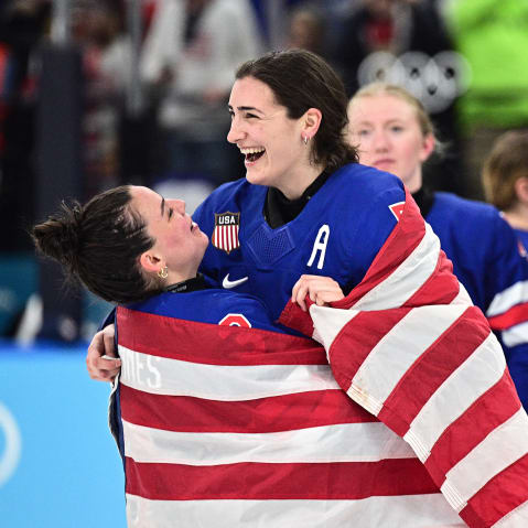 Hockey players in jerseys that read "USA" celebrate with American flags.