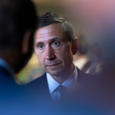 Ken Martin, chairman of the Democratic National Committee, partially obscured by reporters.