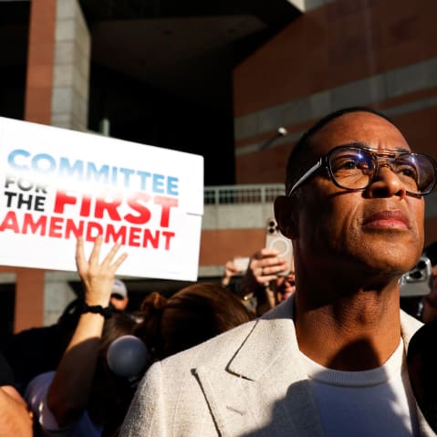 Don Lemon surrounded by people documenting with cameras and cell phones. A person behind him holds a sign that reads "Committee for the First Amendment."