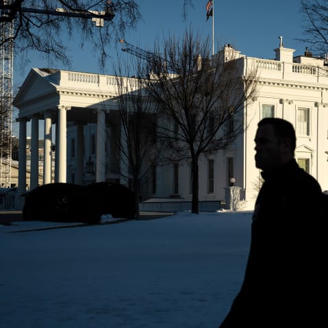 A person walks past the White House.