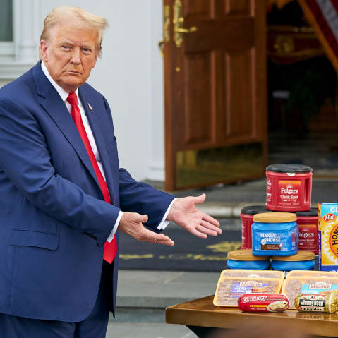 President Donald Trump gestures toward a table of groceries during a news conference.