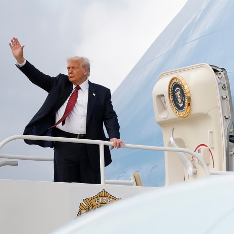 Donald Trump waves on the top step leading into Air Force One.