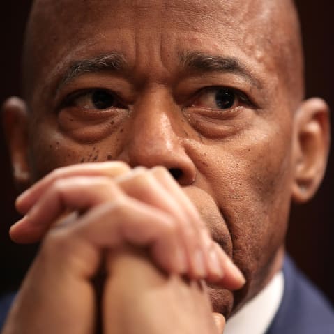 A close up of Eric Adams, whose hands are clasped in front of his mouth.