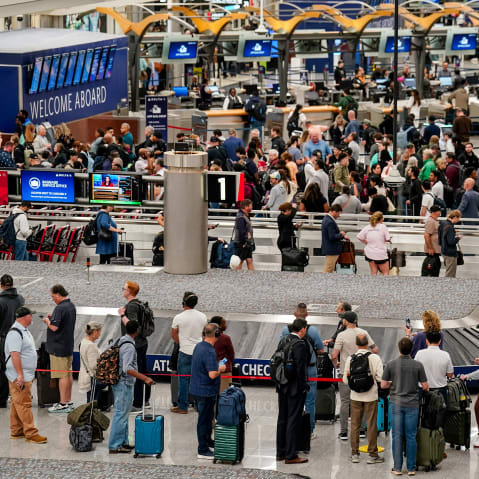 People wait in long lines at the airport.