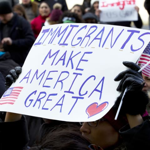Supporters of immigrants' rights march in downtown Washington, D.C. holding sign that reads "Immigrants Makes America Great."