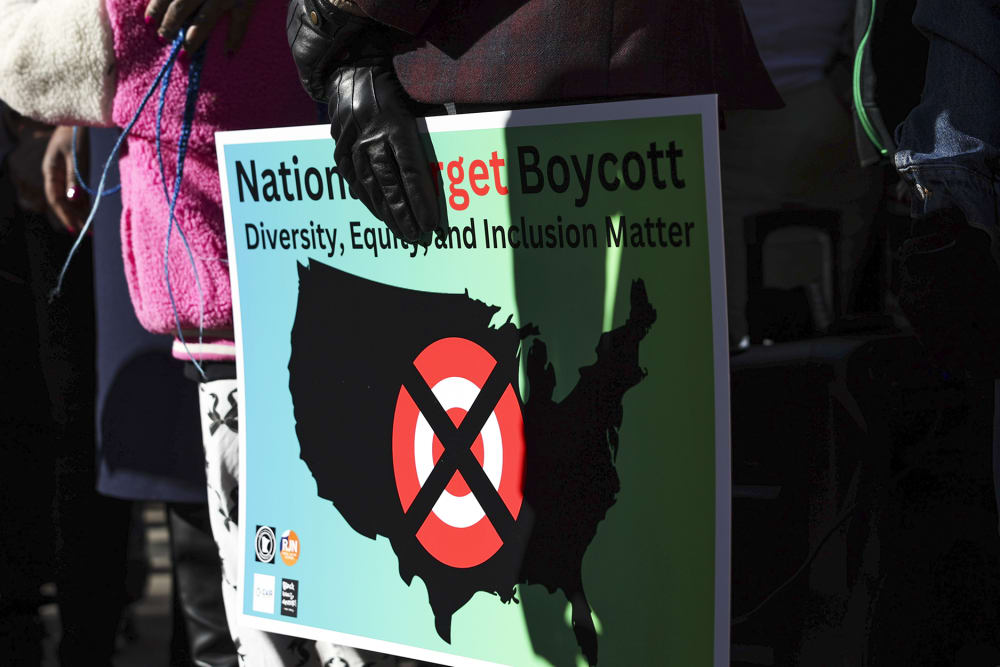 A community member holds a sign calling for a national boycott of Target stores.