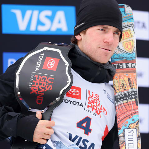 Hunter Hess holds a championship belt and his skis.
