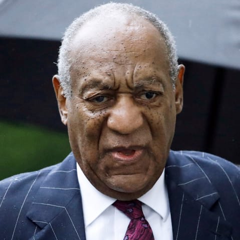 A close up of Bill Cosby looking upset in the rain.