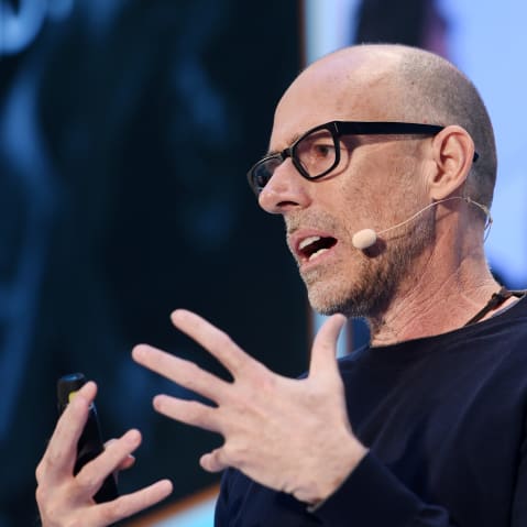 Scott Galloway, with a headset microphone, gestures with his hands.