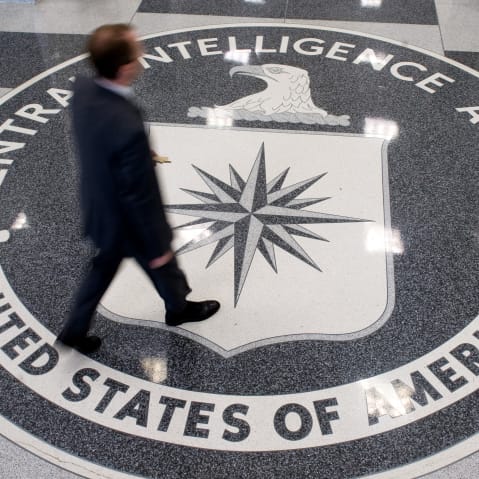 A man crosses the Central Intelligence Agency (CIA) seal in the lobby of CIA Headquarters in Langley, VA.
